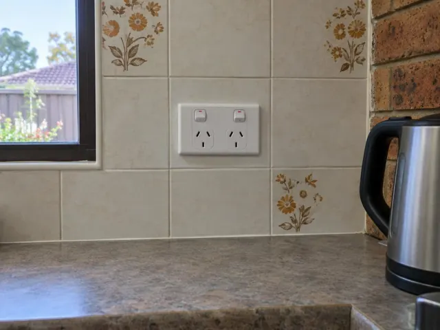 White double power point on tiled kitchen splashback beside a window and brick wall in Budgewoi